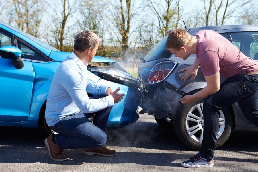 Carolina Collision and Frame Service | Two men after a fender bender going over the damage to their cars on the side of road