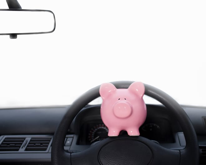 Carolina Collision and Frame Service | Pink piggy bank on the steering wheel of a car