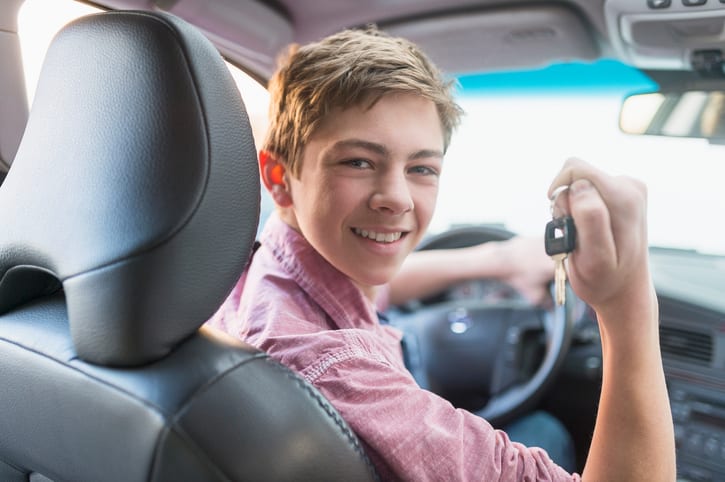Carolina Collision and Frame Service | Young boy smiling holding car keys while sitting in the driver seat of a car