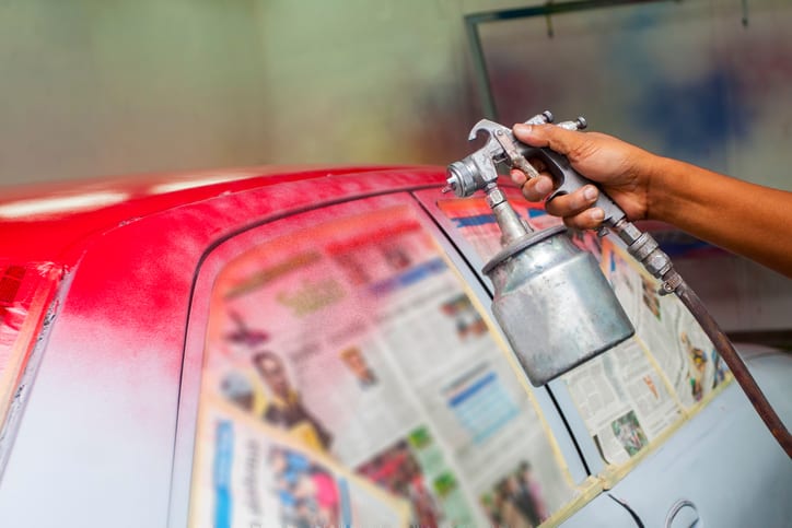 Carolina Collision and Frame Service | Close up of a spray gun painting red paint on a car