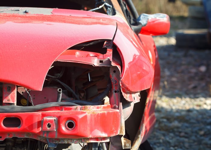 Carolina Collision and Frame Service | Red car with major body damage from an accident