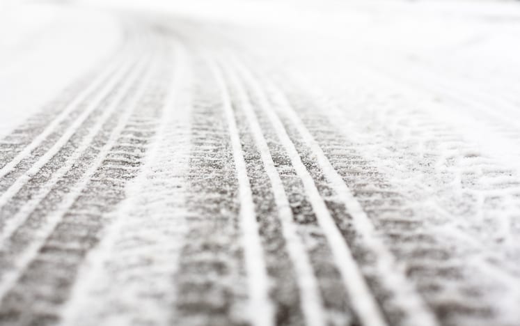 Carolina Collision and Frame Service | Close up of tread marks on a snowy road