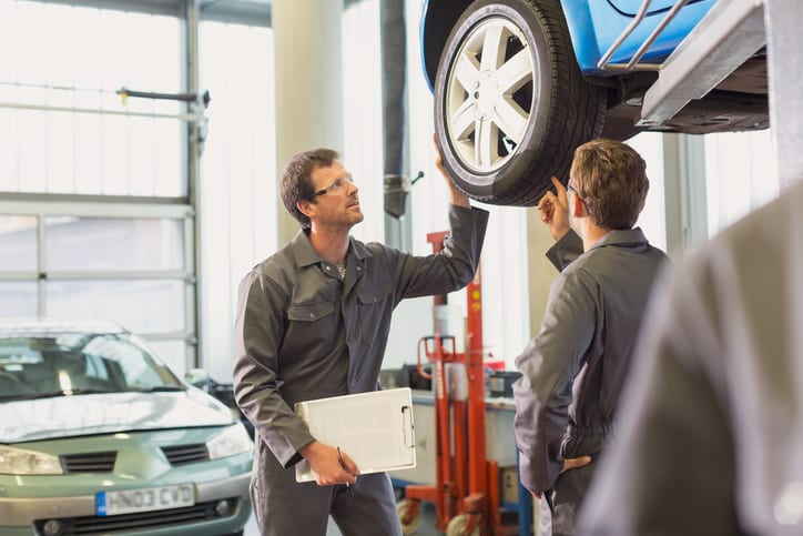 Carolina Collision and Frame Service | Two mechanics inspecting a car on a lift in an auto body repair shop