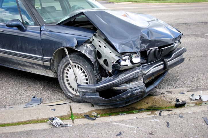 Carolina Collision and Frame Service | Dark blue car on the side of the road with major damage after an accident