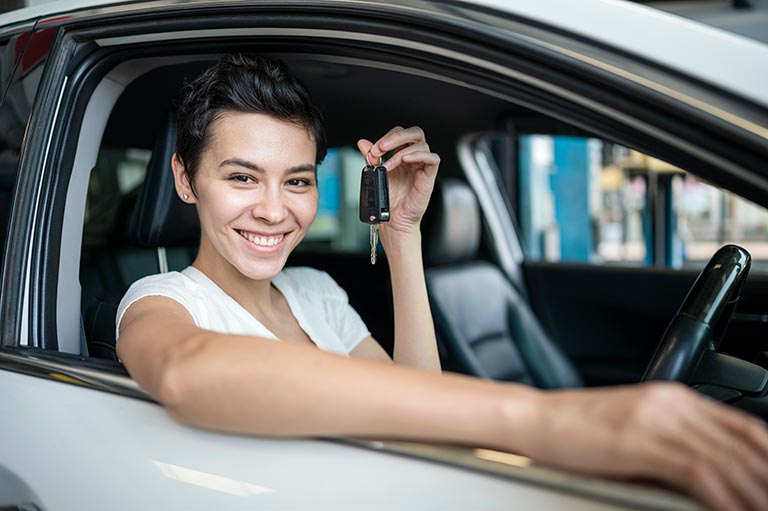 Carolina Collision and Frame Service | Smiling woman wearing a white shirt sitting in a car smiling holding keys